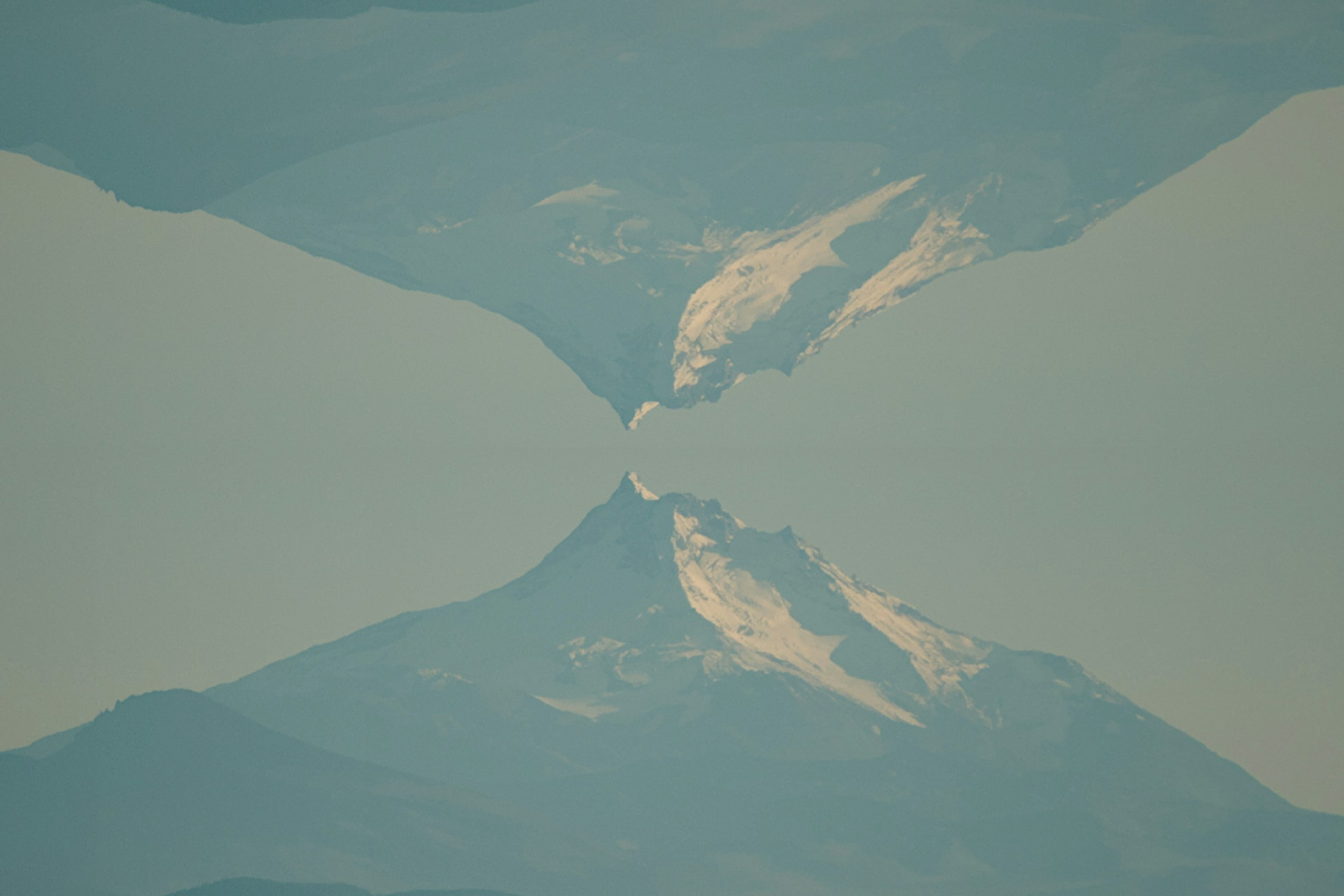 A snow-covered mountain peak and its reflection